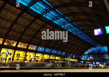 Der Hauptbahnhof von Amsterdam bei Nacht. Zug ist an den Bahnhof. Langzeitbelichtung Nacht Foto. Stockfoto