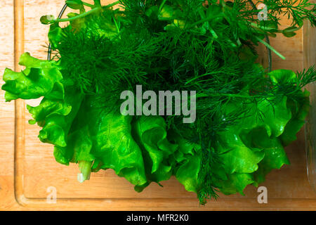 Stapel der frische organische letucce Köpfe. Ernte Haufen frisch geschnittenen grünen Salat Blätter an der hölzernen Tisch. Saubere Konzept essen. Gesunde vegetarische Ernährung fo Stockfoto