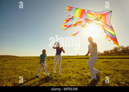 Happy Family spielen mit einem Drachen auf die Natur im Frühling, Sommer. Stockfoto