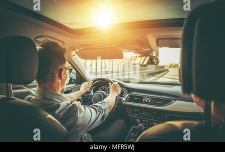 Kaukasische Paar auf der Straße Reise im modernen Fahrzeug mit Schiebedach. Stockfoto