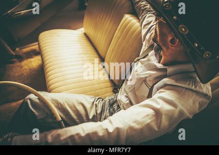 Der Cowboy und seine Fahrt. Kaukasischen Männern in seinem 30s Western tragen in der klassischen amerikanischen Cabriolet. Stockfoto