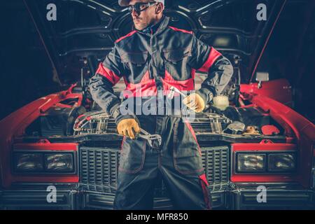 Vintage Classic Car Mechanic. Kaukasische professionelle Mechaniker vor Retro Fahrzeug. Stockfoto