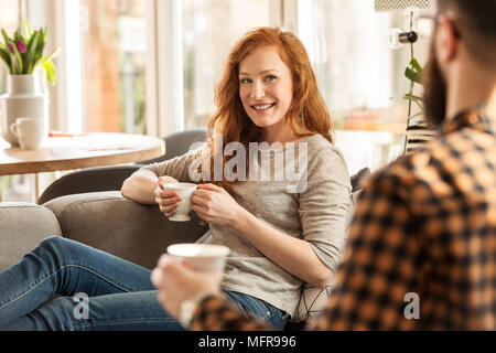 Lächelnde Frau trinkt Tee und liebevoll auf ihr Mann Stockfoto