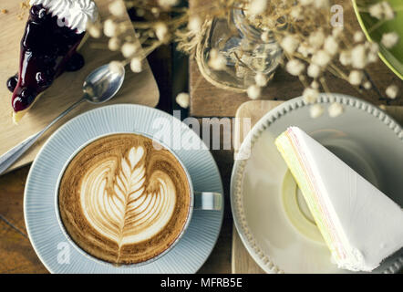 Cappuccino mit Latte Art und tortenheber Desserts Stockfoto