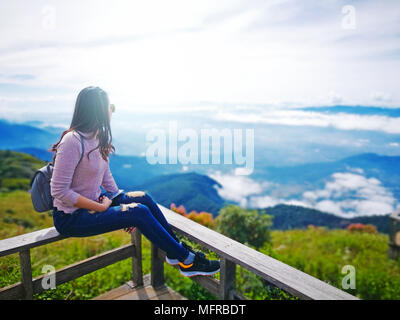 Asiatische Frau trekker sitzen auf hölzernen Terrasse mit schönen Berglandschaft Stockfoto