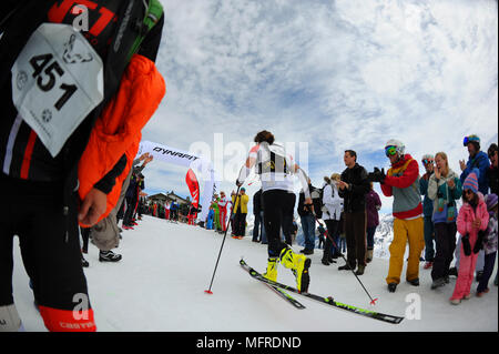 Ein Mann ist, wie er in den X3-triathlon, die mit Skitouren in Courchevel in den Französischen Alpen fertig konkurriert jubelten Stockfoto