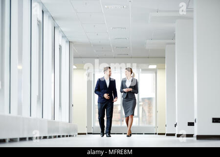 Zuversichtlich Kollegen hinunter in Bürogebäude und Reden Stockfoto