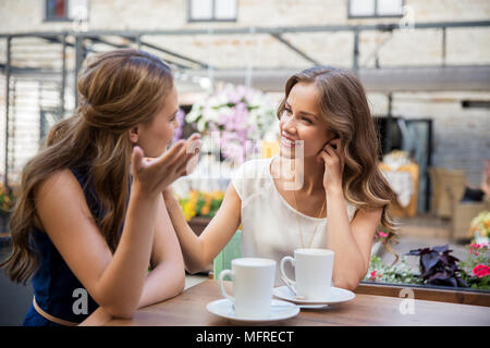 Glückliche junge Frauen trinken Kaffee im Café im Freien Stockfoto