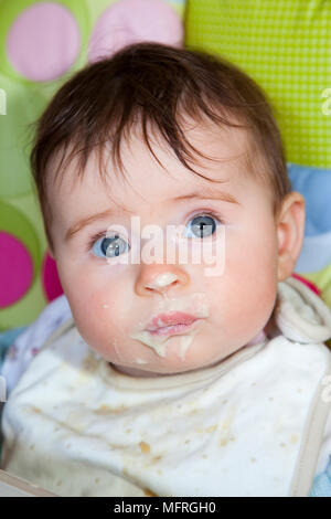 Baby auf einem hohen Stuhl mit Essen auf dem Gesicht. Model Release PS-016 Stockfoto