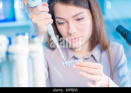 Technikerin mit Pipette in Kop für DNA die gerichtliche Prüfung Stockfoto