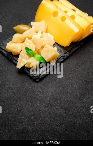 Stücke von Parmesan und Cheddar auf Stein Bord Stockfoto