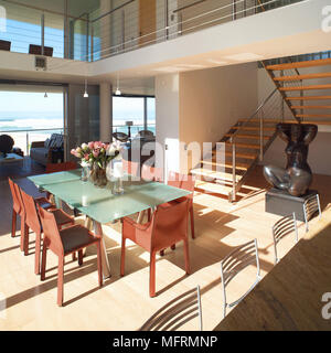 Eine moderne offene Wohnraum mit Essbereich Treppe zur oberen Etage stahl Geländer Glas Tisch Stühle Stockfoto