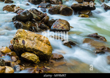 Bewegung verwischt Stromschnellen der Mountain River und nassen Felsblöcken closeup Stockfoto