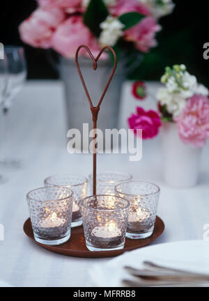 Lit Teelicht Kerzen im Glas Halter auf Tablett auf Tisch draußen Stockfoto