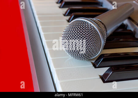 Nahaufnahme von Digital Piano Keyboard mit Mikrofon auf der Roten bacground Stockfoto