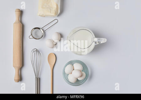 Blick von oben auf die Eier und Milch am weißen Tisch Stockfoto