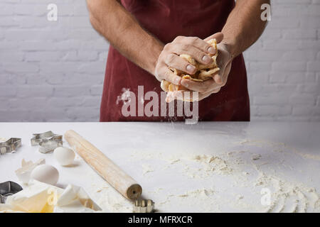 Zugeschnittenes Bild von Chef kneten den Teig in den Händen Stockfoto