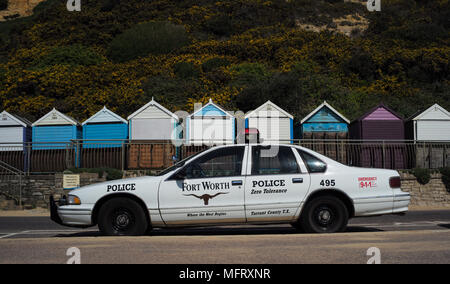 Ein Fort Worth Polizei Auto aus den USA am Strand von Bournemouth in England Dorset geparkt mit Strandhütten im Hintergrund. Stockfoto
