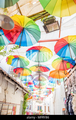 Bunte sonnenschirme Herunterhängen an engen Gassen von Bodrum mit weissen Häusern im griechischen Stil Bodrum Türkei Stockfoto