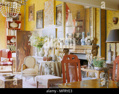 Ein traditionelles gelb Wohnzimmer in einem opulenten Stil mit edlen Möbeln Muster Tapete Kamin Tisch Stühle dekoriert Stockfoto