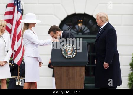 Der französische Präsident Emmanuel Längestrich, küsst die Hand der First Lady Melania Trump als US-Präsident Donald Trump, rechts, und Brigitte Längestrich, Links, auf die im formellen Begrüßungszeremonie auf dem Rasen des Weißen Hauses April 24, 2018, Washington, DC. Längestrich ist auf einem Staatsbesuch in Washington, der erste Präsident seit Trump Amt übernahm. Stockfoto