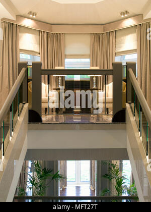 Glas Geländer bis zur Landung mit Sesseln vor der Tür von Haus Pflanzen flankiert Stockfoto