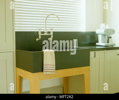 Butler Waschbecken auf hölzernen Beinen in der Küche mit Hellgrün Einheiten Stockfoto