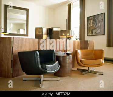 Retro Stil Wohnzimmer mit Ledersesseln und Holz- Bildschirme Stockfoto