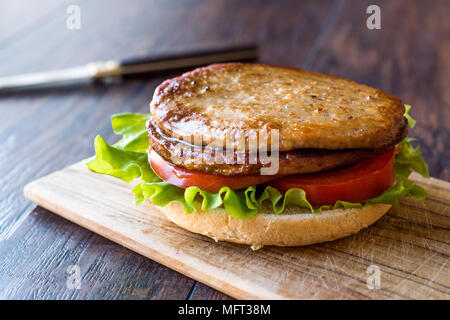 Doppelklicken Sie Burger mit der Türkei Fleisch, Salat und Tomaten auf Holz- Oberfläche. FastFood Konzept. Stockfoto