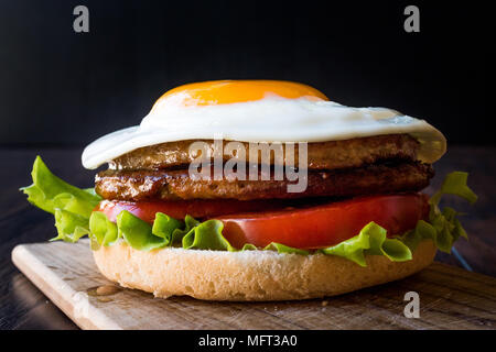 Hausgemachte Doppel Hamburger mit Ei, Salat und Tomaten. FastFood Konzept. Stockfoto