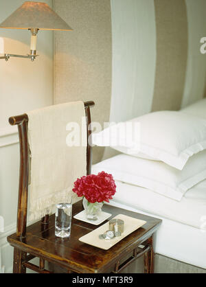 Schlafzimmer, moderne Bed orientalische Möbel Wandleuchte auf beige Doppelbett weißen Bettdecken und Kopfkissen Stühle Wandleuchte Glas Wasser Blumen in gla Stockfoto