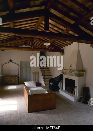 Landhausstil Wohnzimmer mit Holzbalkendecke, ein Sofa und tierischer