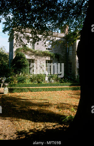 Ein Detail eines von außen ein Georgianisches Landhaus aus Stein und Gärten, Rasen, Bäume am späten Nachmittag Sonne, Stockfoto