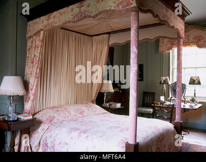 Ein traditionelles Schlafzimmer mit einem Himmelbett mit Baldachin und Vorhänge, Beistelltisch Stockfoto