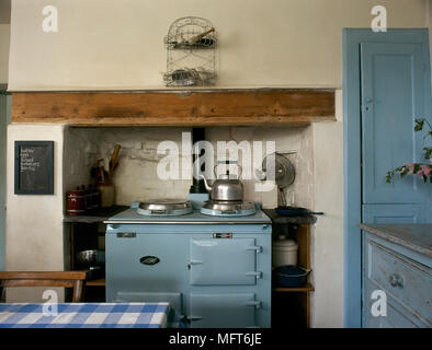 Land Küche mit distressed Schränke und eine blaue Backofen in einer Nische an der Wand. Stockfoto