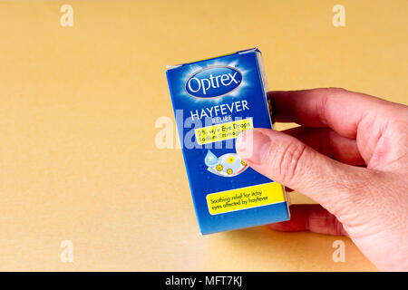 Weibliche Hand, die eine Box mit Optrex Heuschnupfen Allergie Auge Tropfen, Vereinigtes Königreich Stockfoto