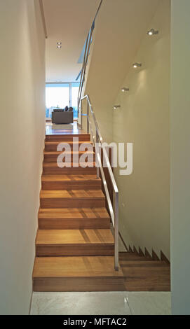 Ansicht von unten der Holztreppe mit Geländer aus Metall Stockfoto