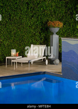 Sonnenliege neben Schwimmbad Stockfoto