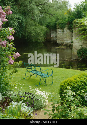 Land Garten mit Metall Bank vor Fluss, Warwickshire, Großbritannien Stockfoto