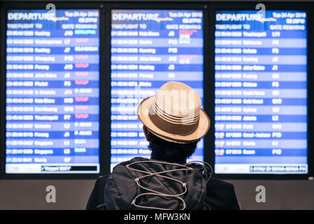 Junge Erwachsene tourist Traveler rucksacktouristen am Flughafen Flugplan Zeitplan auf dem Bildschirm suchen. Urlaub, Reise Tourismus und Urlaub Konzept Stockfoto