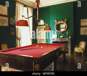 Eine traditionelle grüne Spiele Zimmer eine rote Snookertisch Deckenlicht, Kamin Zeitraum vergoldeten Stuhl Stockfoto