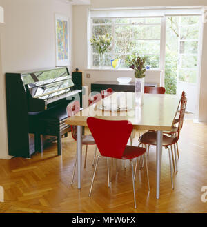 Ein modernes weißes Esszimmer Holz Tisch rot Arne Jacobsen Stühle piano Holz Parkett Stockfoto