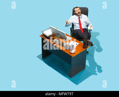 Aufnahme von oben auf eine stilvolle Geschäftsmanns, der auf dem Laptop. Junge glücklicher Mann am Tisch sitzen. Business und Workplace Konzept. Menschliche Gefühle eine Stockfoto