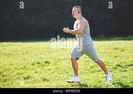 Fitness Mensch Sportler Joggen in der Natur während des Sonnenuntergangs. Person, die einen aktiven Lebensstil Training cardio im Sommer in Sportswear und Schuhe. Stockfoto