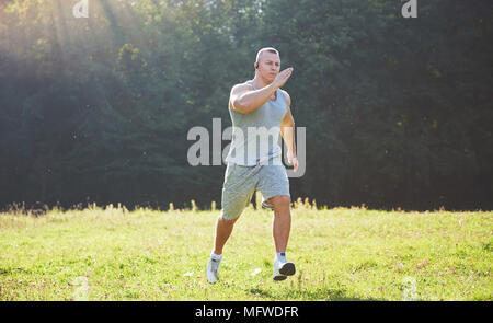 Fitness Mensch Sportler Joggen in der Natur während des Sonnenuntergangs. Person, die einen aktiven Lebensstil Training cardio im Sommer in Sportswear und Schuhe. Stockfoto