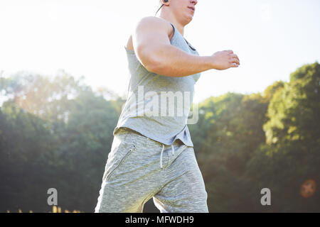 Fitness Mensch Sportler Joggen in der Natur während des Sonnenuntergangs. Person, die einen aktiven Lebensstil Training cardio im Sommer in Sportswear und Schuhe. Stockfoto
