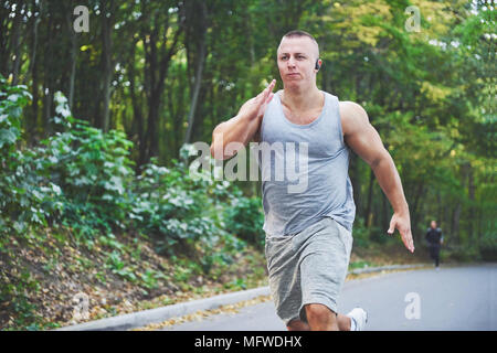 Fitness Mensch Sportler Joggen in der Natur während des Sonnenuntergangs. Person, die einen aktiven Lebensstil Training cardio im Sommer in Sportswear und Schuhe. Stockfoto