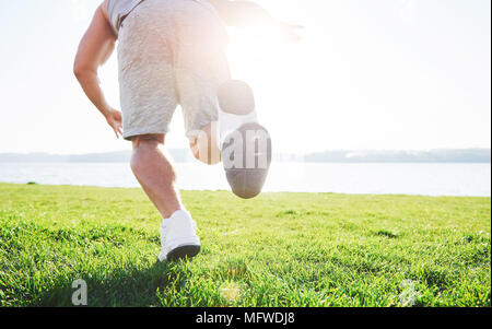 Fitness Mensch Sportler Joggen in der Natur während des Sonnenuntergangs. Person, die einen aktiven Lebensstil Training cardio im Sommer in Sportswear und Schuhe. Stockfoto