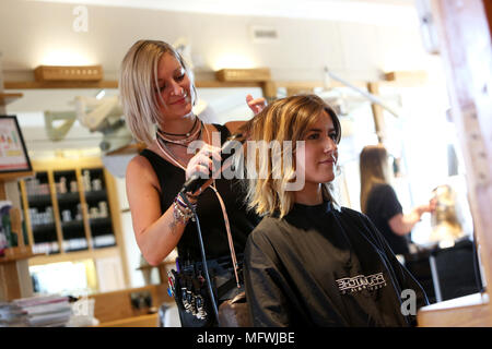 Ein Friseur dargestellt an einem jungen Mädchen die Haare zu einem Friseure in Chichester, West Sussex, UK. Stockfoto