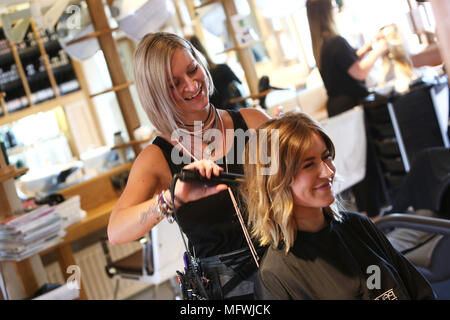 Ein Friseur dargestellt an einem jungen Mädchen die Haare zu einem Friseure in Chichester, West Sussex, UK. Stockfoto